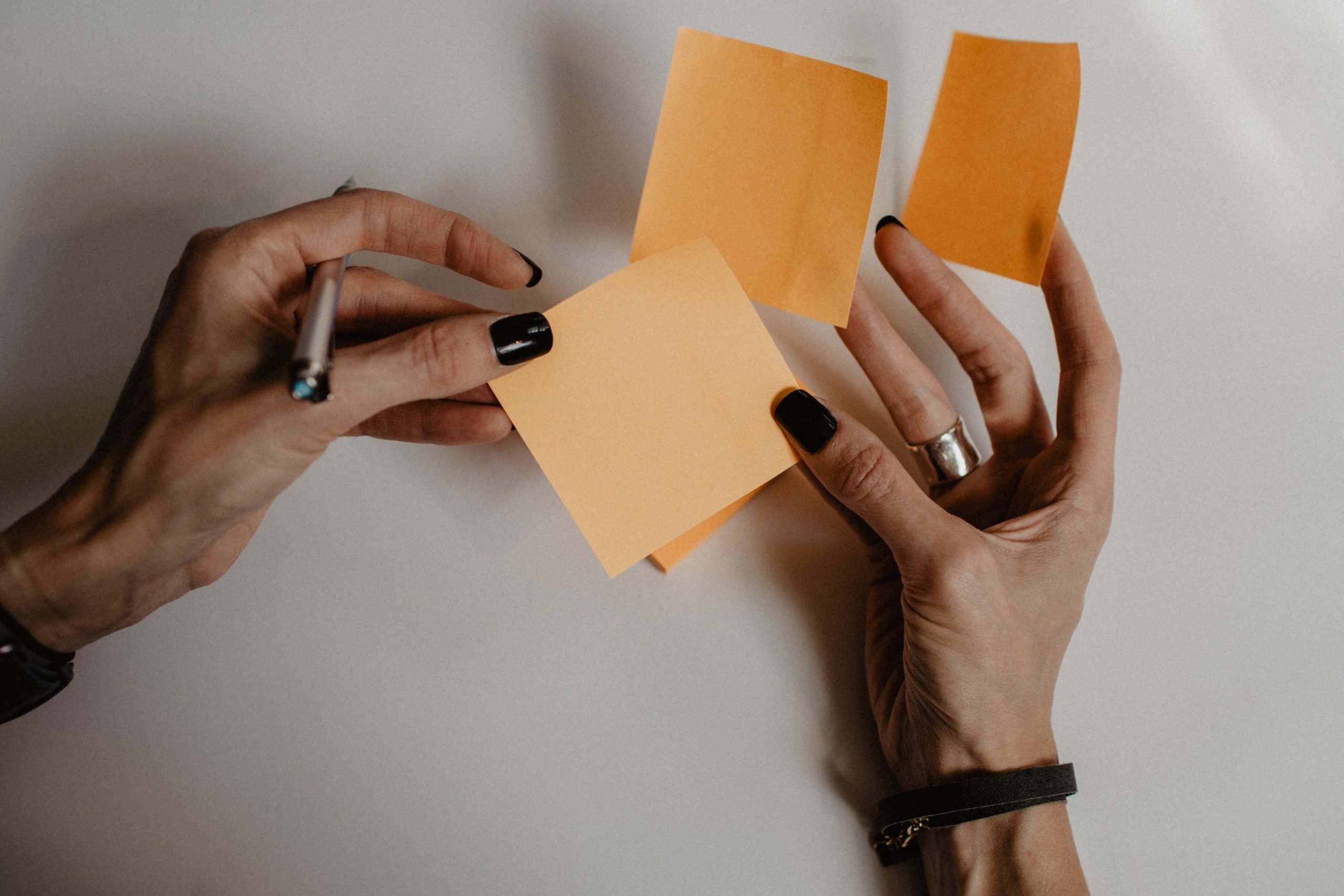 A woman's hands holding sticky notes.