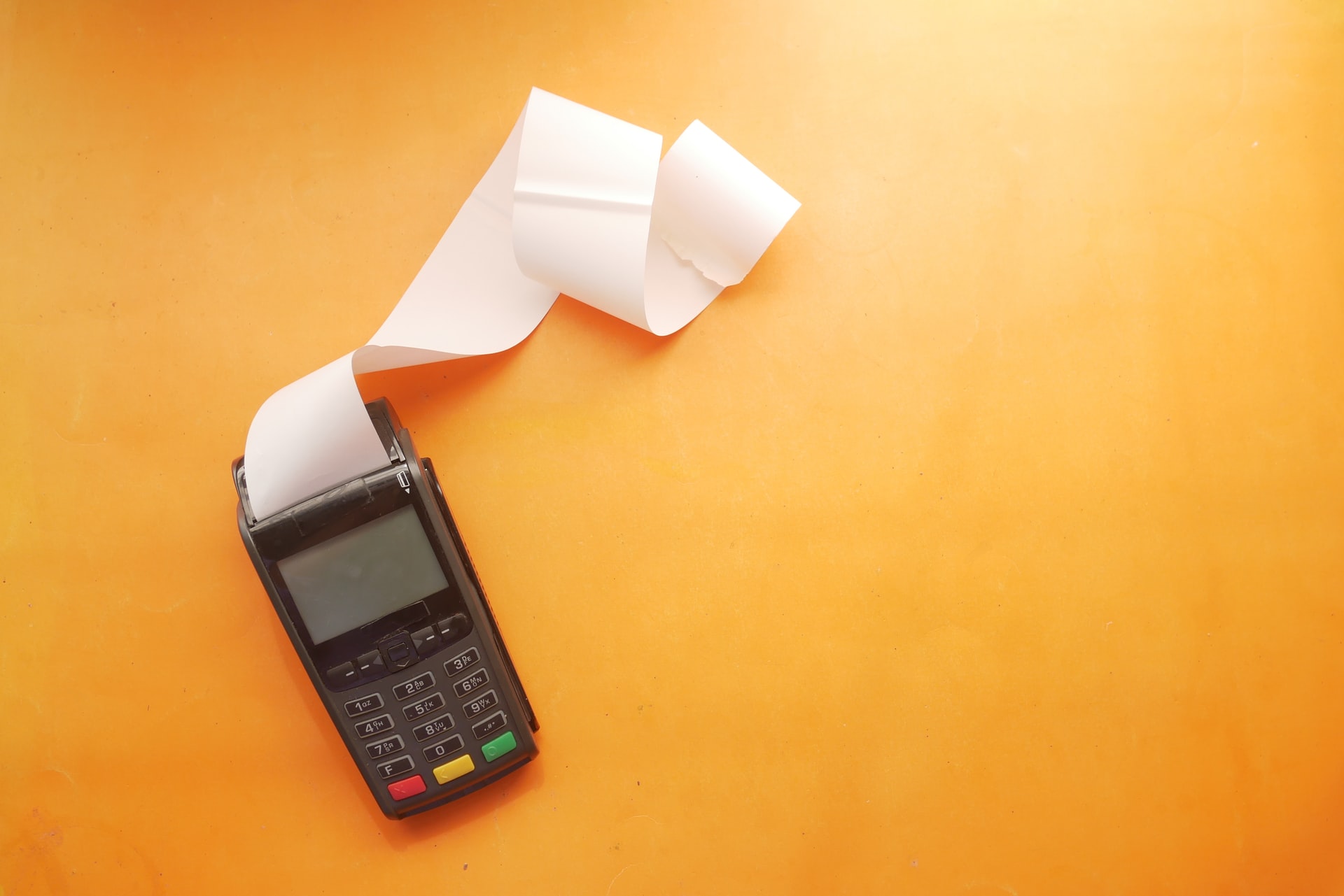 A calculator with a printer showing expenses for a business.