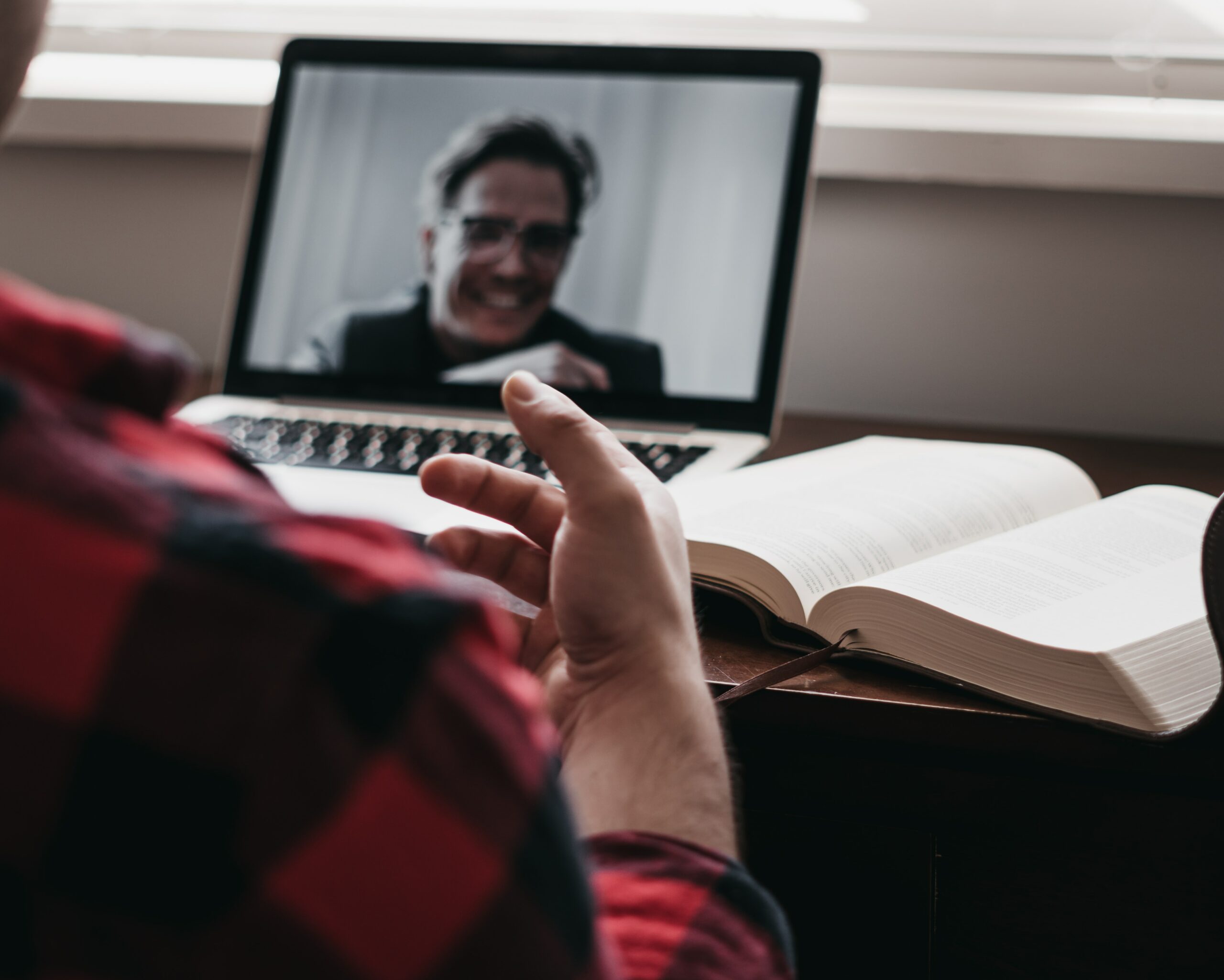 A man talking to a happy man on a video call asking bookkeeping interview questions