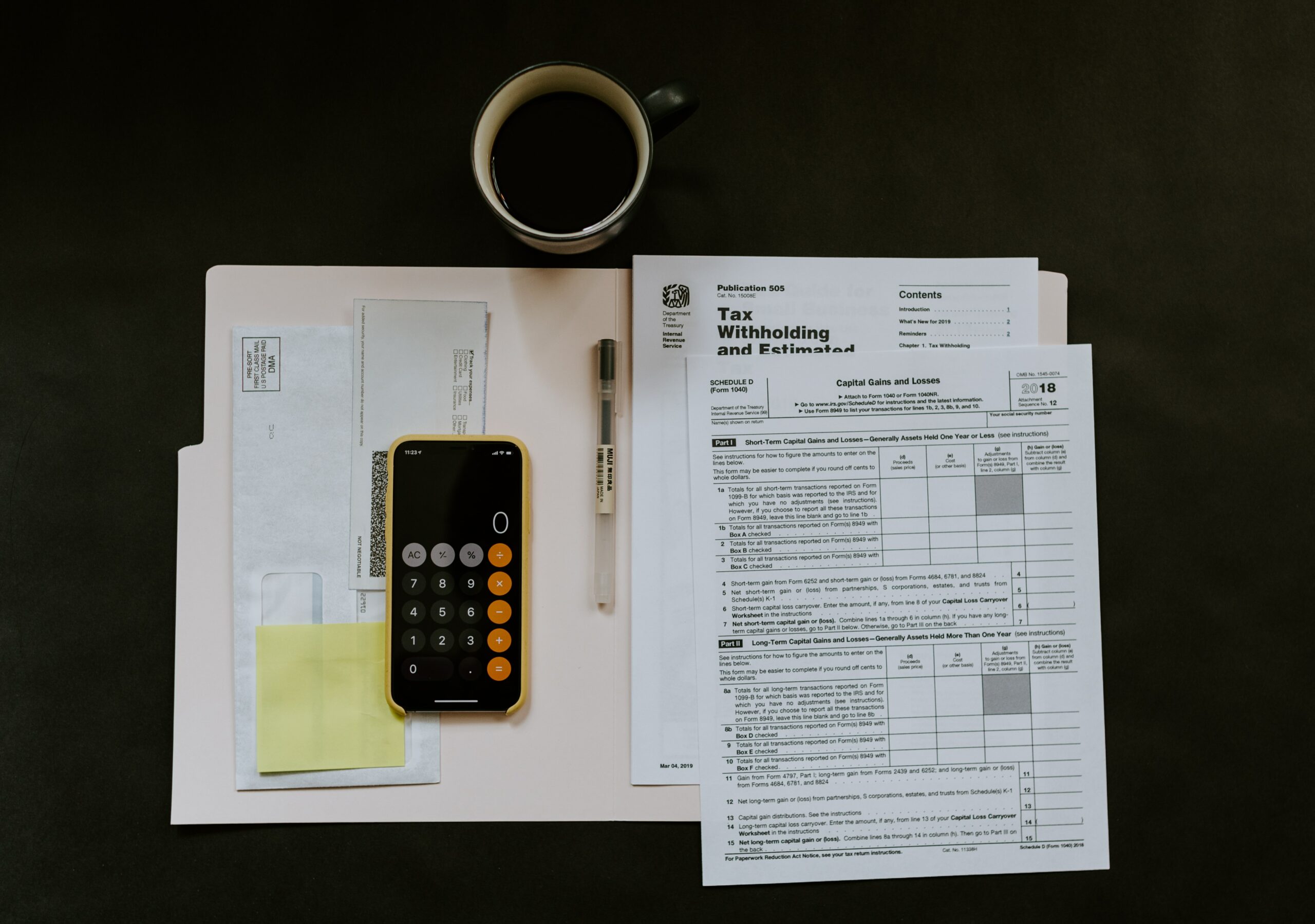 Various accounting papers like Amazon seller tax documents with a mug and a calculator on a table.