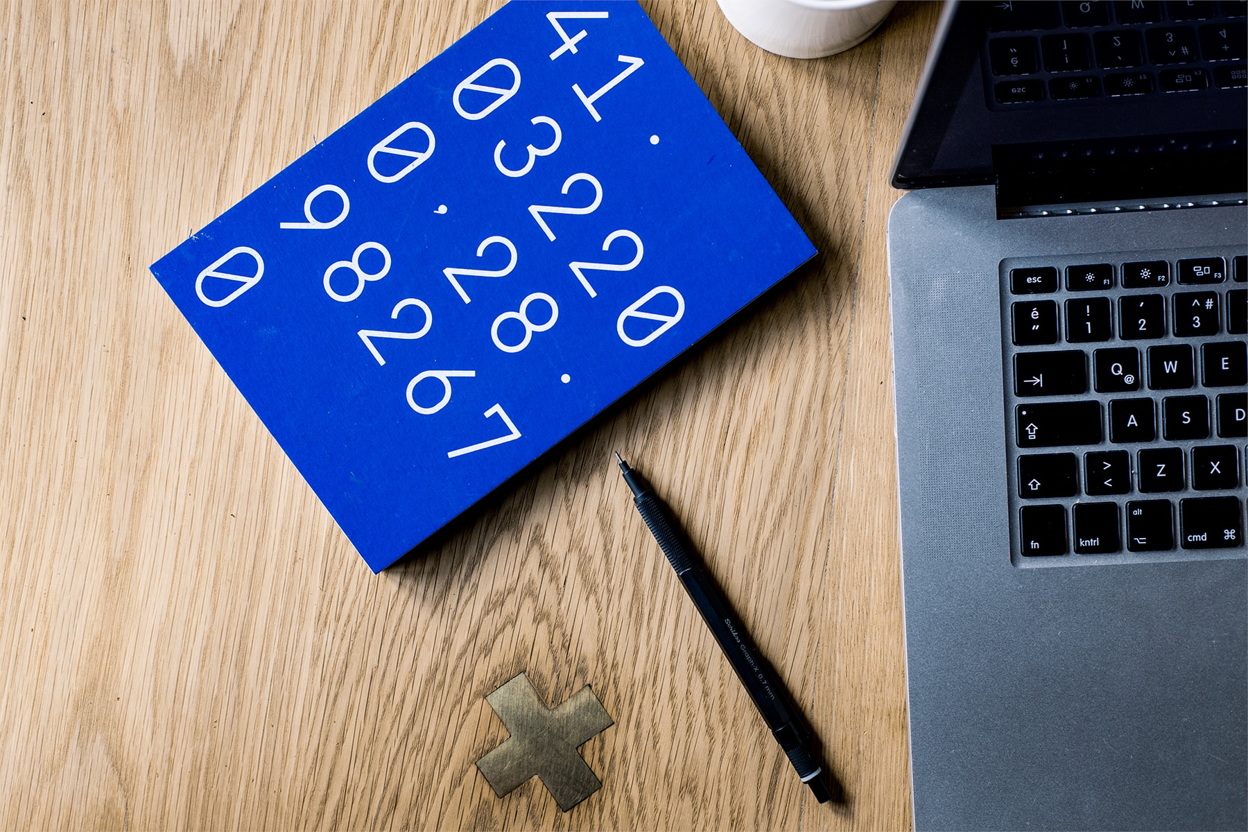 A laptop next to a calculator and pen. Computing for gross merchandise value