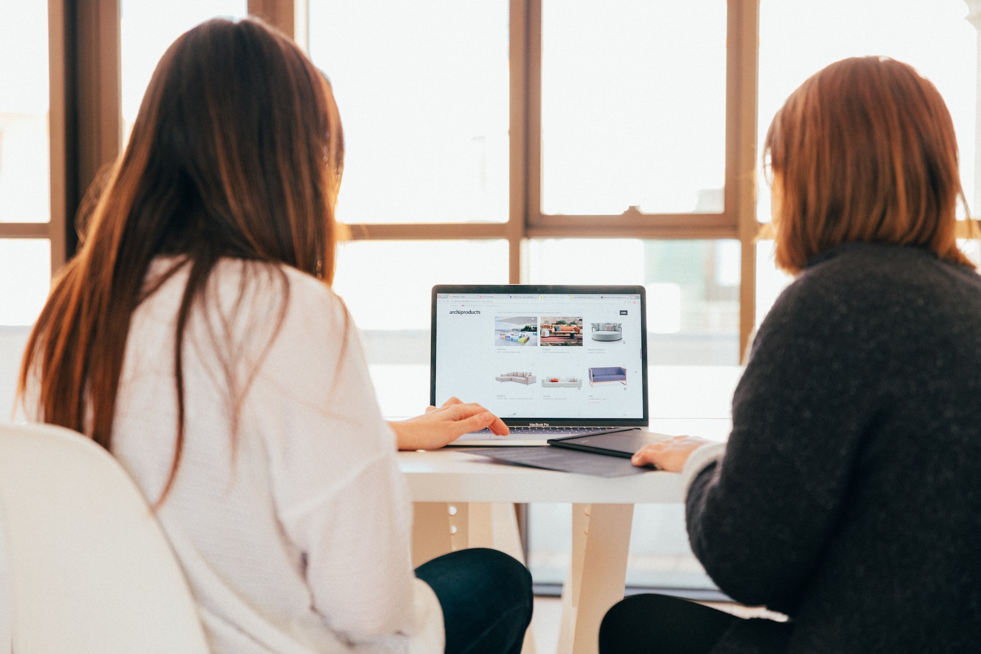 Two women looking at software on a laptop.