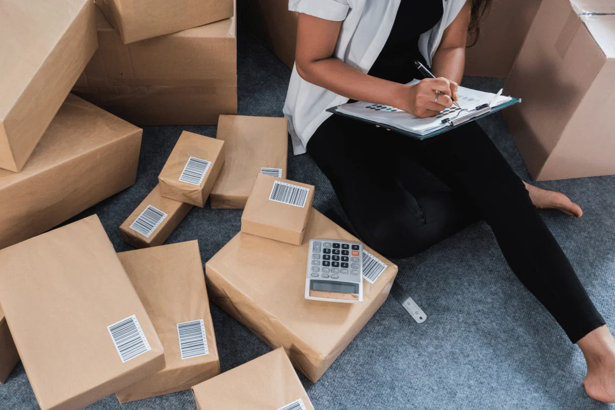 Small business owner managing online orders while talking on the phone.