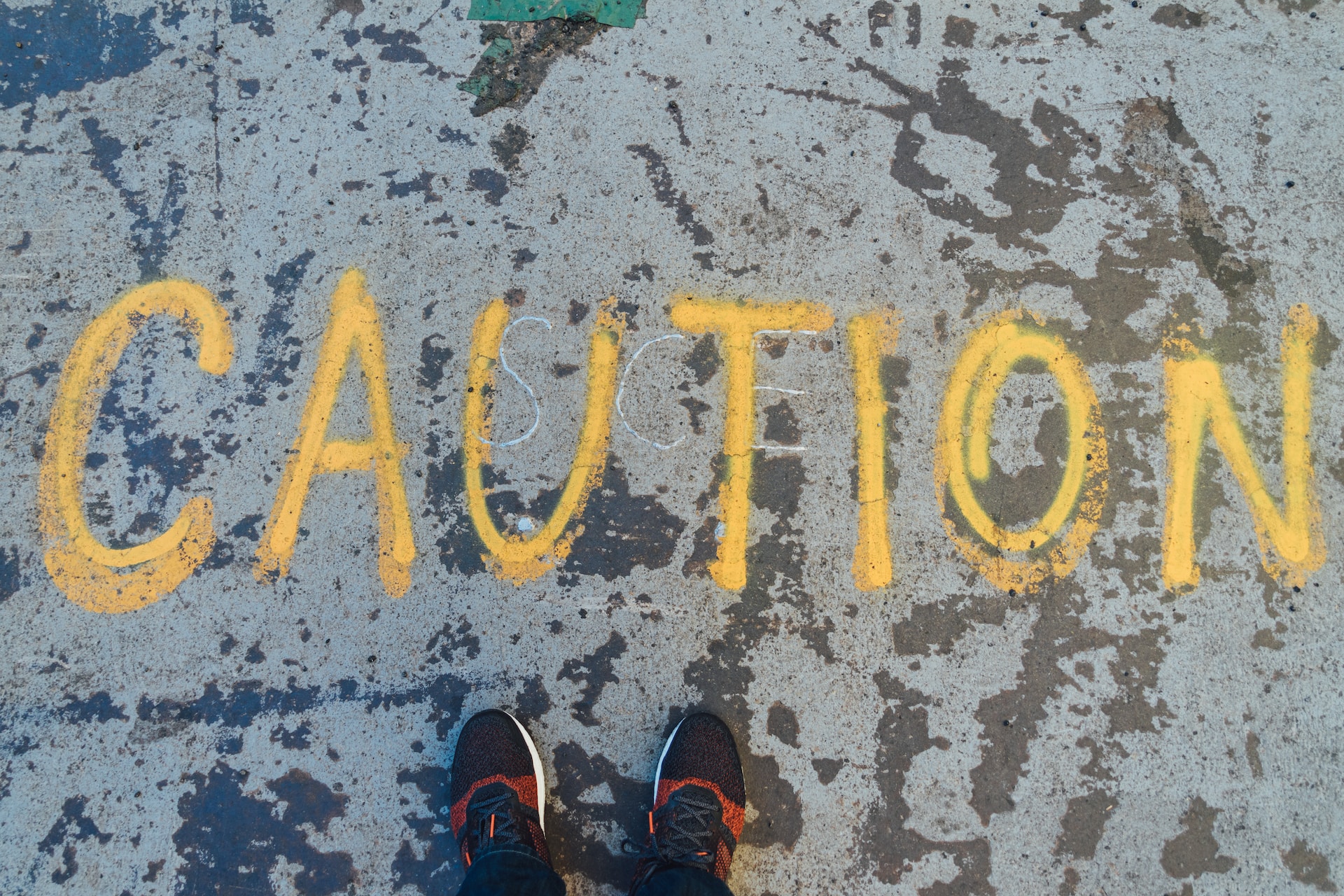 The word "caution" written on the ground in dark yellow chalk.