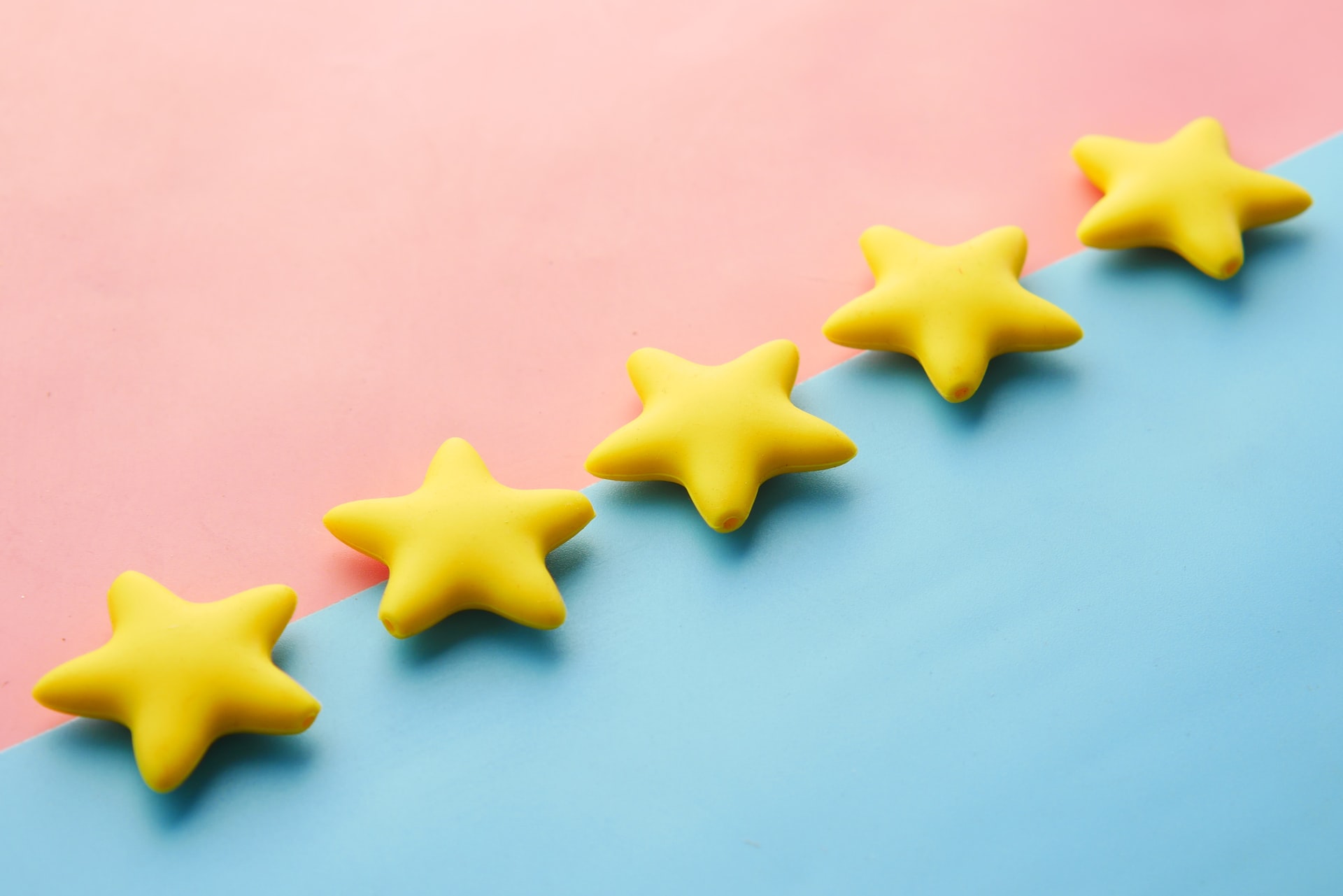 Five yellow stars on a pink and blue background representing Amazon seller reviews.