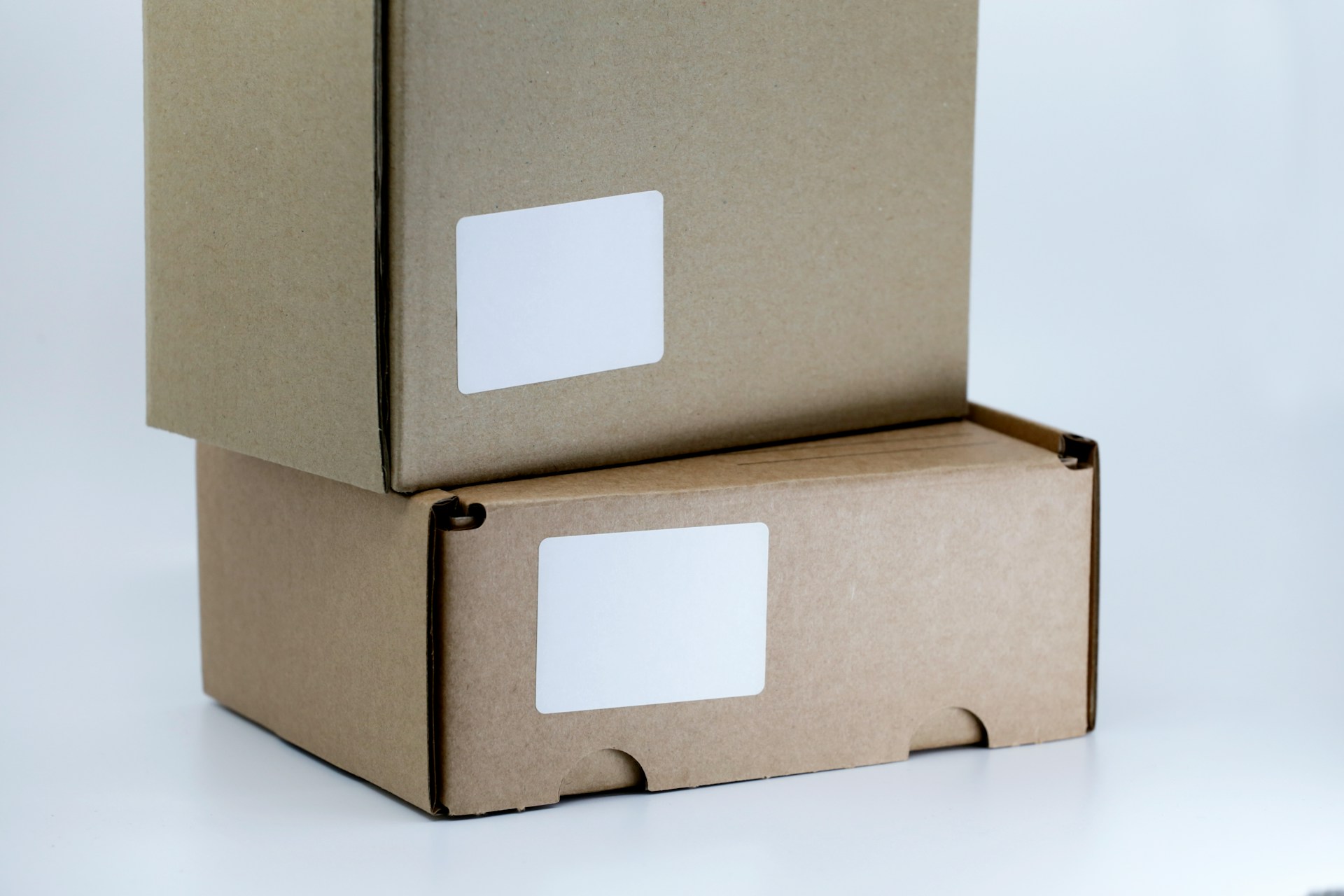 Two plain shipping boxes with blank labels for Amazon FBA vs dropshipping.