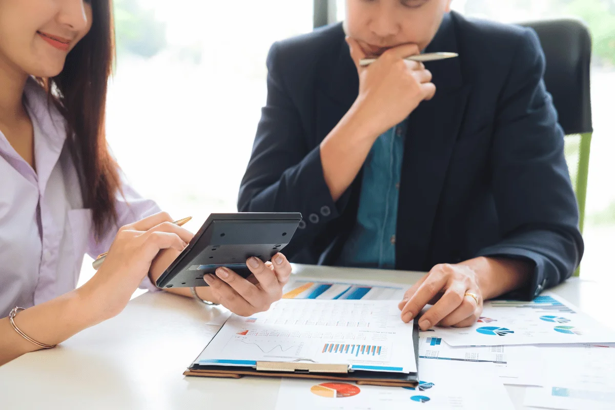 Two business professionals analyzing financial data and discussing reports.