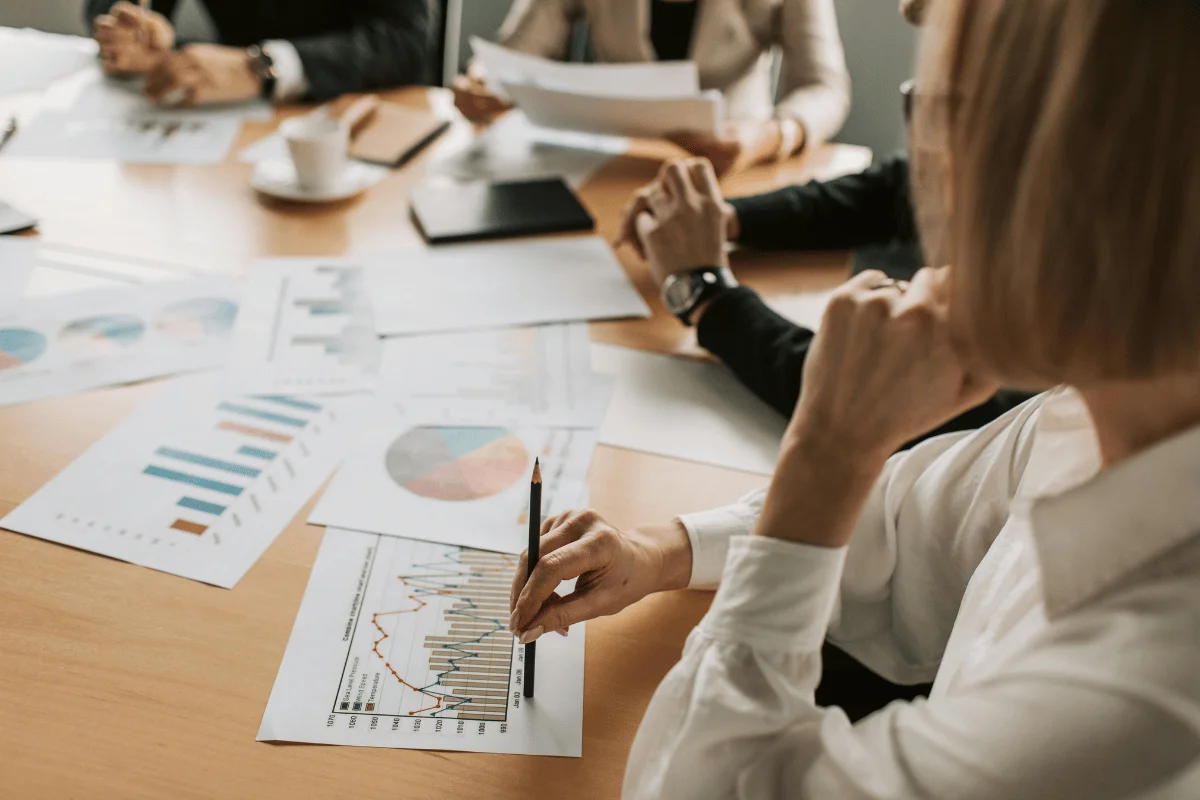 Business professionals analyzing financial charts and graphs in a meeting.